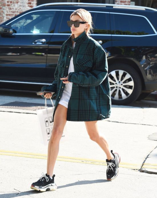 Hailey Baldwin近日于洛杉矶街拍，私服身着Balenciaga T恤及球鞋，Yeezy格纹衬衫，Carmar牛仔半裙。